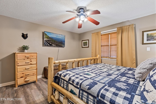 bedroom with ceiling fan, dark wood-type flooring, and a textured ceiling