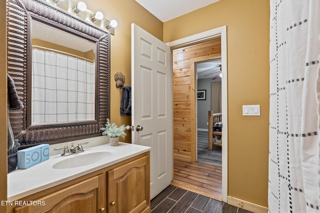 bathroom featuring walk in shower, vanity, and a textured ceiling