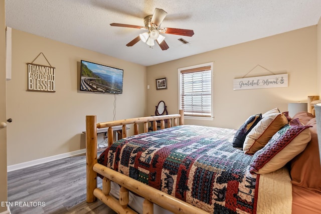 bedroom with dark hardwood / wood-style flooring, ceiling fan, and a textured ceiling