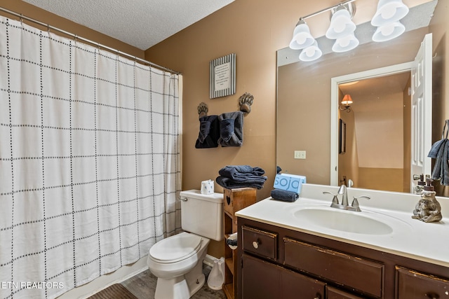 bathroom with a shower with curtain, vanity, toilet, and a textured ceiling