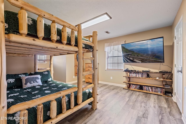 bedroom featuring hardwood / wood-style flooring and multiple windows