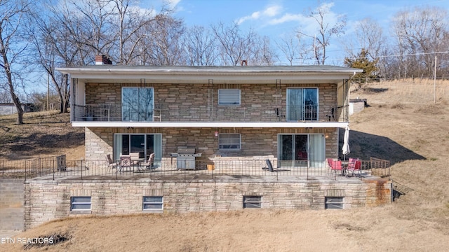 rear view of house with a patio and a balcony