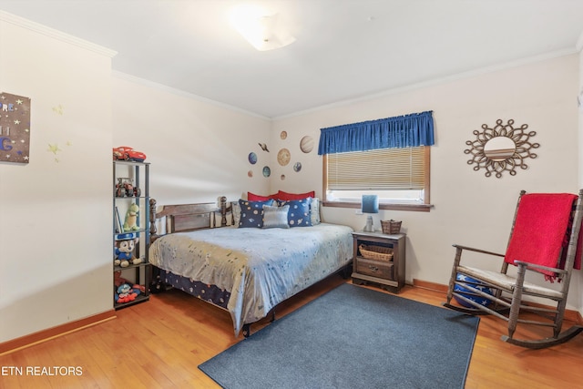 bedroom with wood-type flooring and ornamental molding