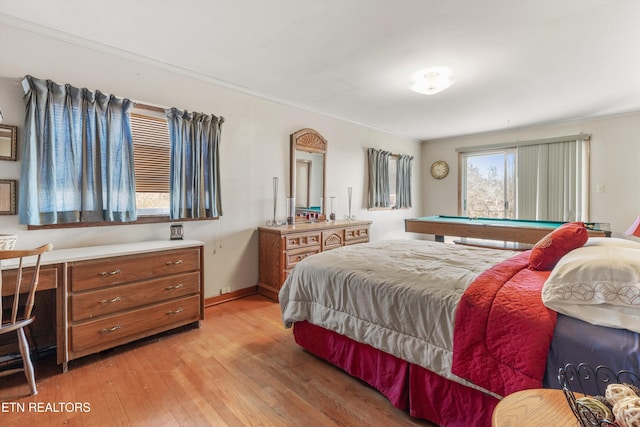 bedroom featuring crown molding, built in desk, and light hardwood / wood-style floors