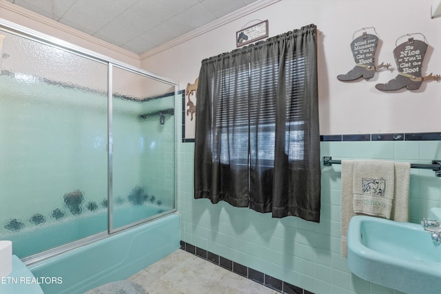 bathroom featuring ornamental molding, sink, tile walls, and shower / bath combination with glass door