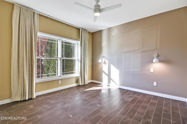 empty room with dark hardwood / wood-style flooring and ceiling fan