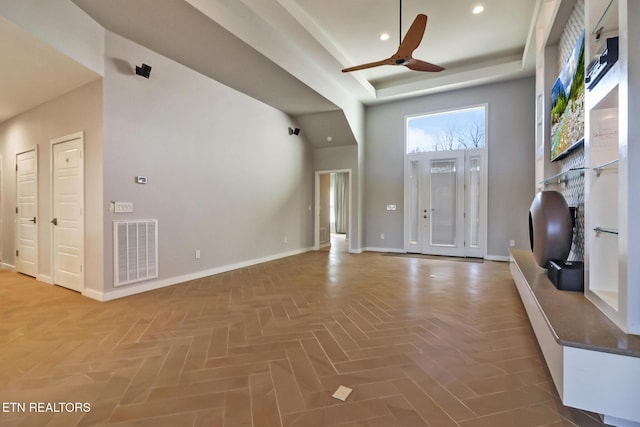 unfurnished living room featuring a high ceiling, parquet flooring, and ceiling fan