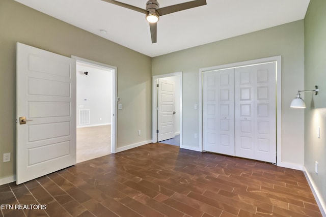 unfurnished bedroom with dark wood-type flooring, a closet, and ceiling fan