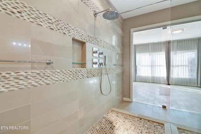 bathroom with tile patterned flooring and tiled shower