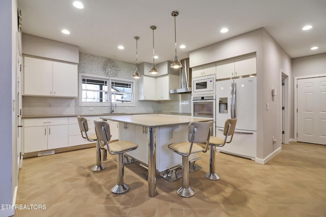 kitchen with a kitchen island, pendant lighting, white cabinets, backsplash, and white appliances