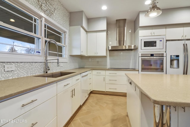 kitchen with white cabinetry, sink, white appliances, and wall chimney exhaust hood