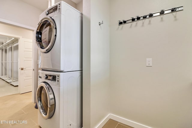 laundry room with stacked washing maching and dryer and light tile patterned flooring