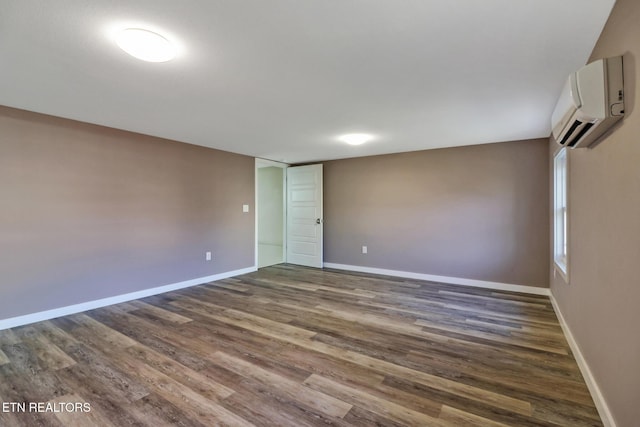 empty room featuring dark hardwood / wood-style floors and a wall mounted air conditioner