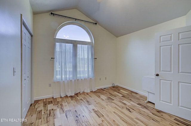 unfurnished bedroom with lofted ceiling and light wood-type flooring