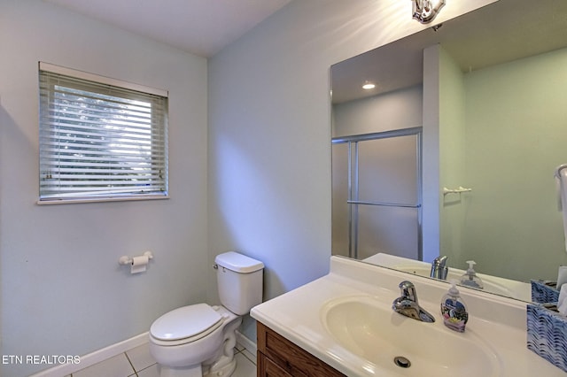 bathroom with tile patterned flooring, vanity, toilet, and walk in shower