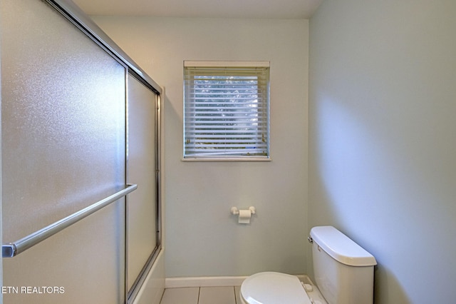 bathroom featuring shower / bath combination with glass door, toilet, and tile patterned flooring