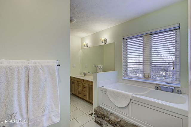 bathroom featuring tile patterned flooring, vanity, a bath, and a textured ceiling