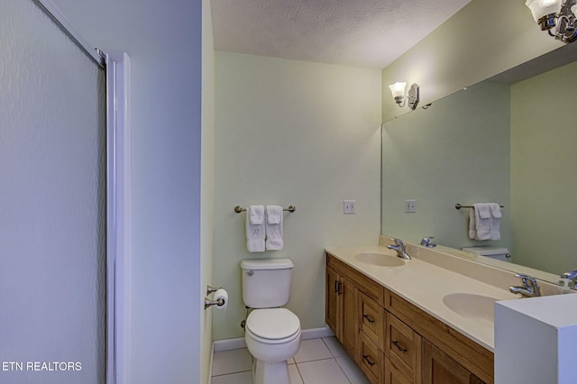 bathroom featuring walk in shower, toilet, a textured ceiling, vanity, and tile patterned flooring