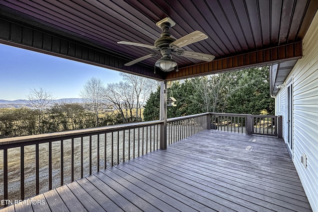 wooden deck featuring ceiling fan and a mountain view