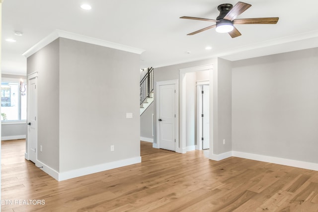 spare room with crown molding, ceiling fan, and light wood-type flooring