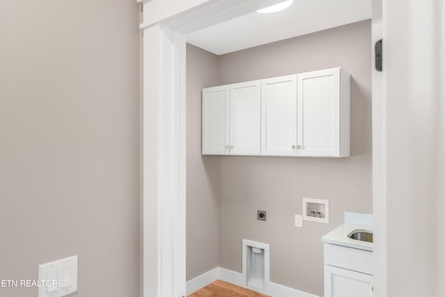 laundry room featuring cabinets, hookup for a washing machine, hookup for an electric dryer, and light hardwood / wood-style flooring