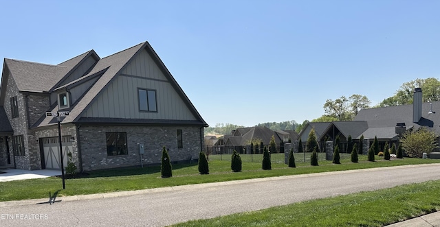 view of side of property featuring fence, brick siding, board and batten siding, concrete driveway, and a yard