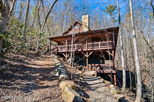 rear view of property with a chimney and a wooden deck