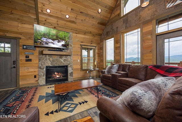 living room with a mountain view, a healthy amount of sunlight, a fireplace, and wood walls