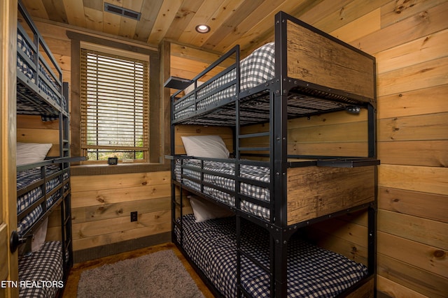 bedroom with wood ceiling and wooden walls