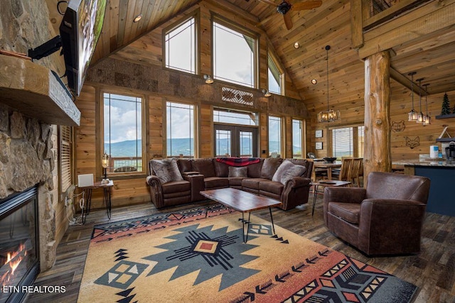 living room with dark wood-type flooring, high vaulted ceiling, wooden ceiling, wooden walls, and a fireplace