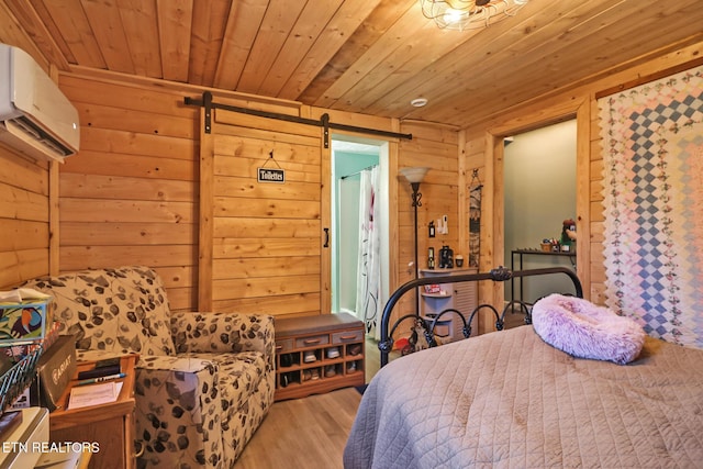 bedroom with light hardwood / wood-style flooring, wooden walls, a wall unit AC, wooden ceiling, and a barn door