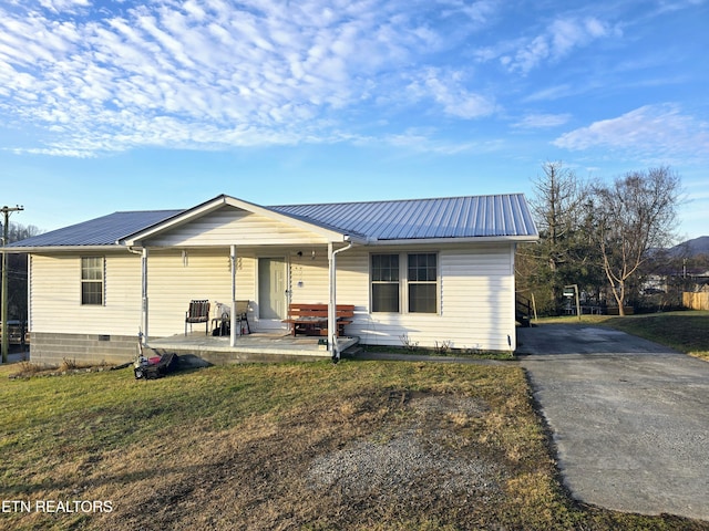 single story home featuring covered porch and a front lawn