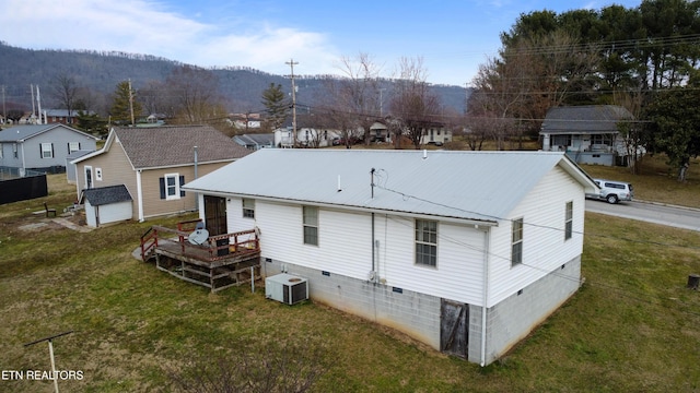 rear view of property with cooling unit and a lawn