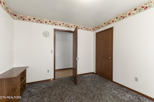 unfurnished bedroom featuring dark carpet