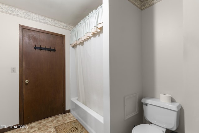 bathroom featuring shower / tub combo with curtain and toilet