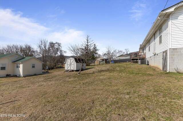 view of yard featuring central air condition unit and a storage shed