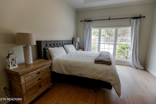 bedroom with crown molding and light wood-type flooring