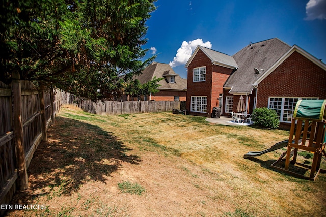 view of yard featuring a playground and a patio area