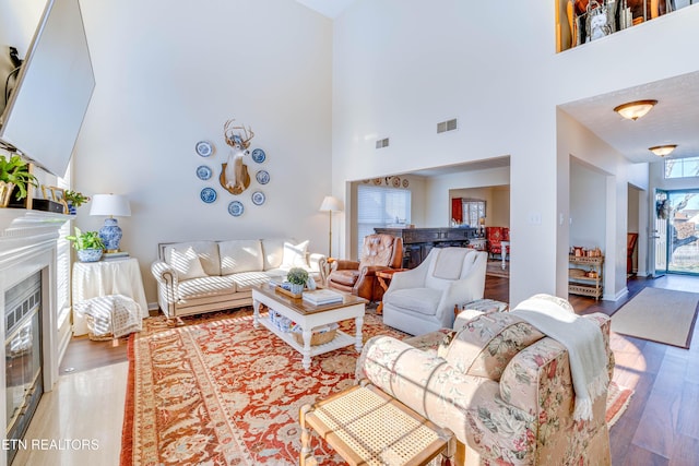 living room featuring a high ceiling and hardwood / wood-style floors