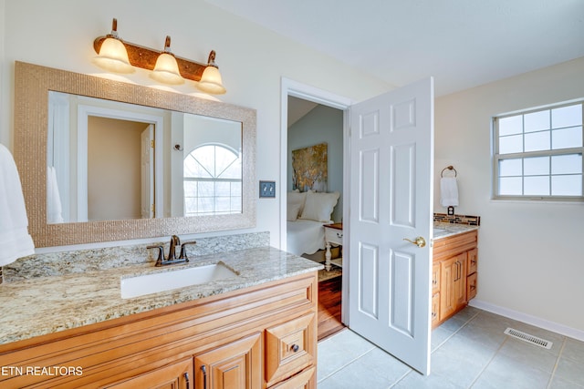 bathroom with vanity, tile patterned flooring, and a healthy amount of sunlight