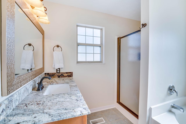 bathroom with vanity, backsplash, tile patterned flooring, and plus walk in shower