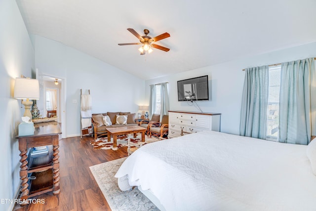 bedroom with vaulted ceiling, dark wood-type flooring, and ceiling fan