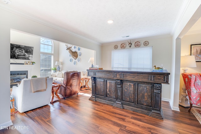 living room featuring ornamental molding, dark hardwood / wood-style floors, and a textured ceiling