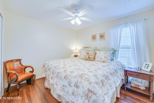 bedroom with dark hardwood / wood-style floors and ceiling fan