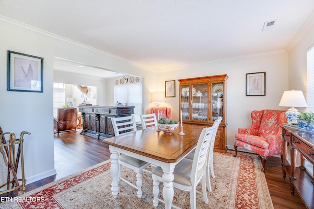 dining area with dark hardwood / wood-style flooring and crown molding