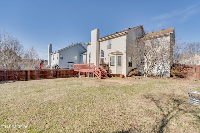 back of property featuring a lawn and a deck