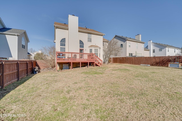 rear view of property with a lawn and a deck