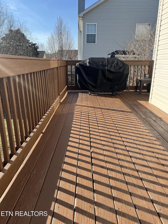 wooden deck featuring a grill