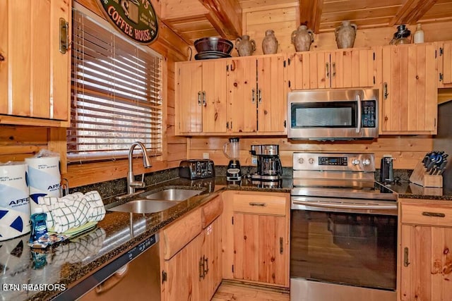 kitchen with sink, wood ceiling, dark stone counters, stainless steel appliances, and beam ceiling