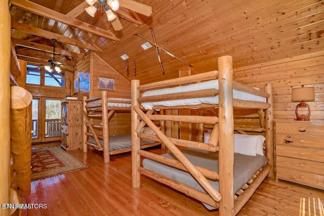 bedroom featuring wood ceiling, high vaulted ceiling, wooden walls, and light hardwood / wood-style floors